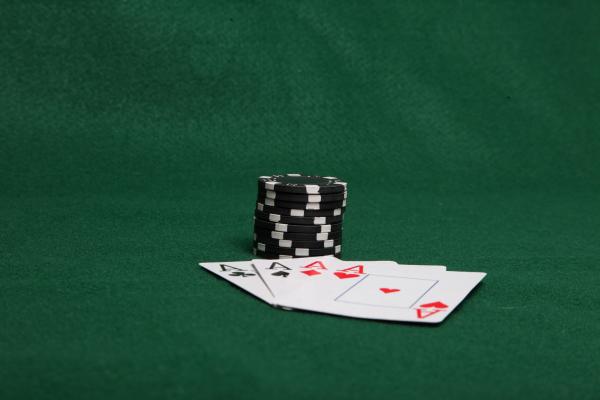 Stack of black poker chips with four ace