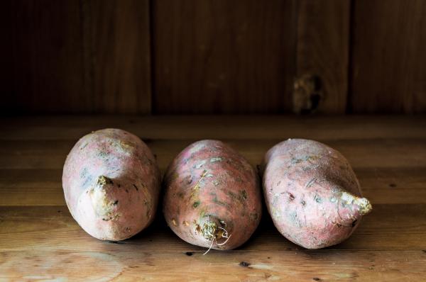 Sweet potatoes on wooden background