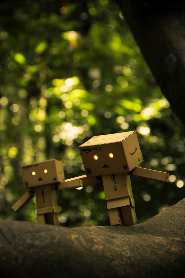 Three Brown Cardboard Box Figures on Brown Surface