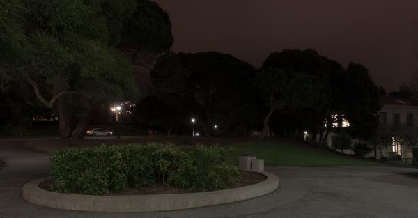 Trees and walkway outside Tolman Hall entrance at night