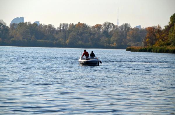Two fishermen on a boat in the middle of the river
