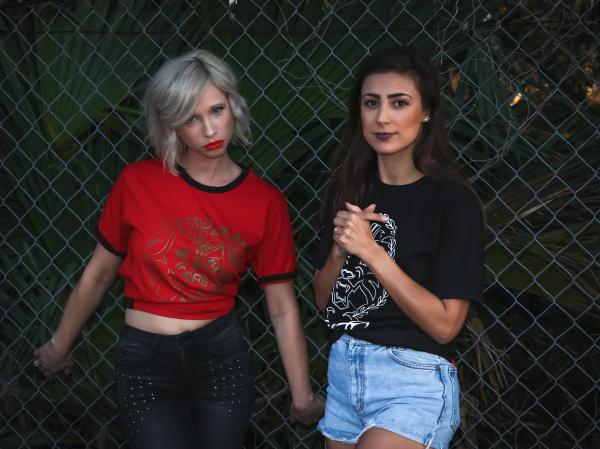 Two Woman Leaning on Fence