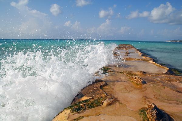 Water breaking over a seaside barrier