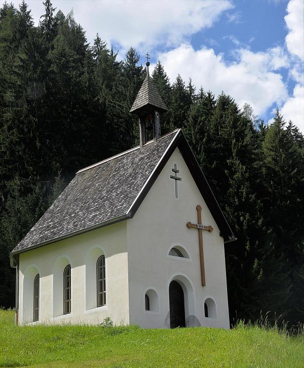 White and Black Cathedral Surrounded by Trees Under White Clouds