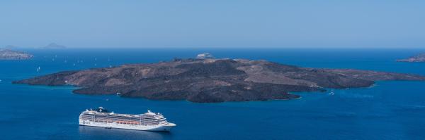 White Crewship Near Island Under Clear Sky at Daytime