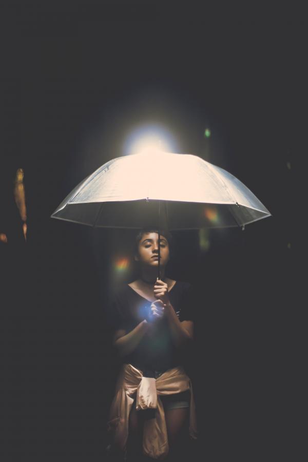 Woman Holding Illuminated Lamp at Night