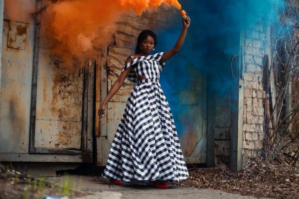 Woman in Black and White Plaid Dress Holding Torch