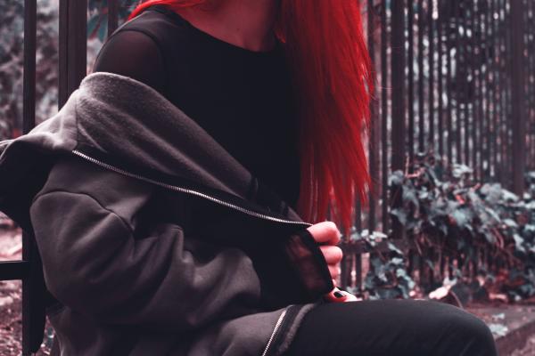 Woman in Black Zip-up Jacket Near Green Leaf Plant