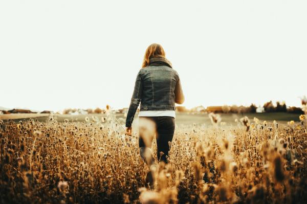 Woman in Blue Denim Jacket Walking on Field
