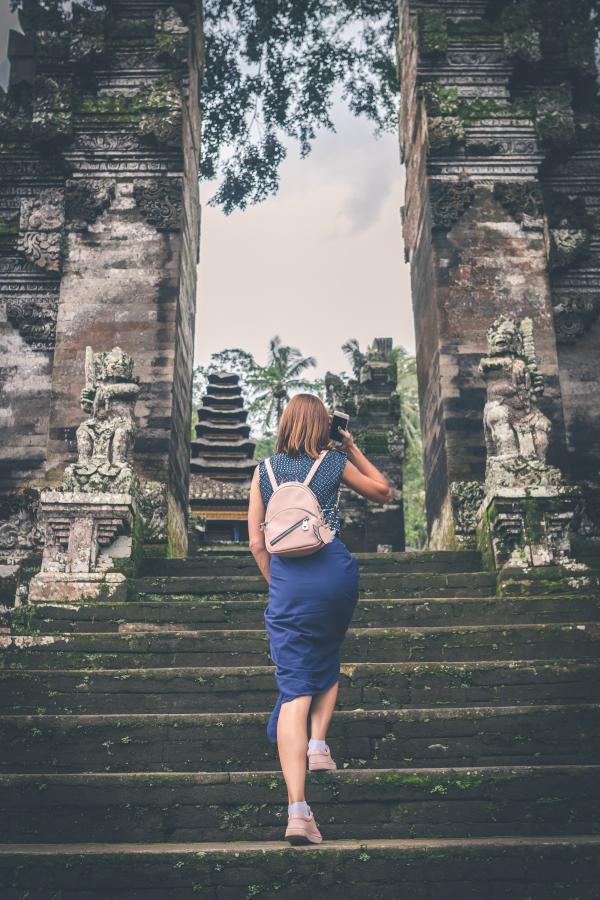 Woman in Blue Dress Walking on Concrete Staircase Leading to Buildings