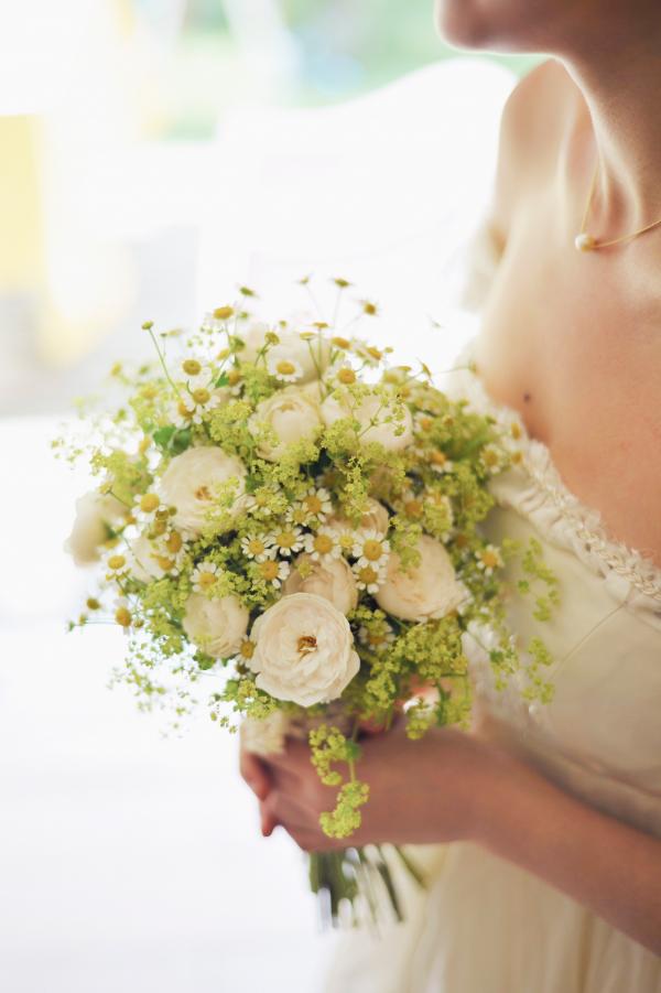 Woman in Bridal Gown Holding Bouquet of White Flowers