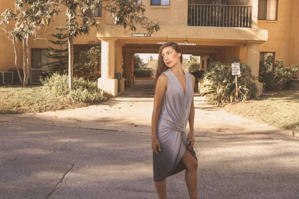 Woman in Gray Deep V-neck Sleeveless Tulip Dress Standing on Gray Floor