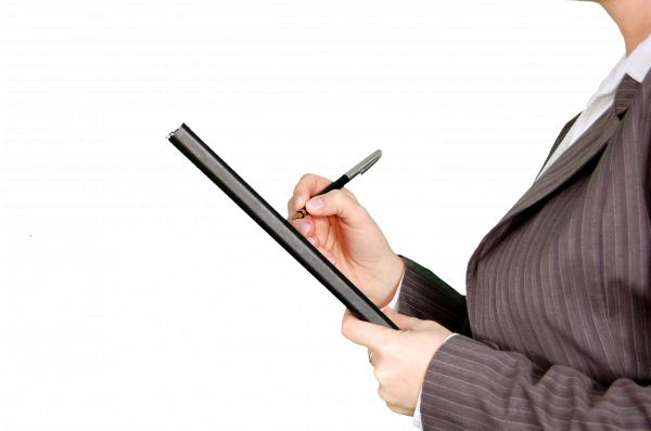 Woman in Gray Pinstripe Blazer Holding Black and Gray Stylus Pen and Black Pad