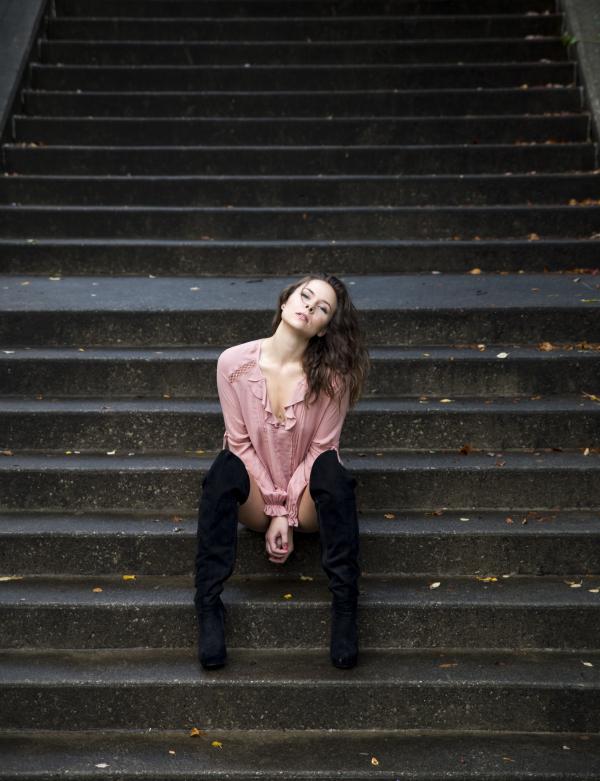 Woman in Pink Dress Shirt Sitting on Stares