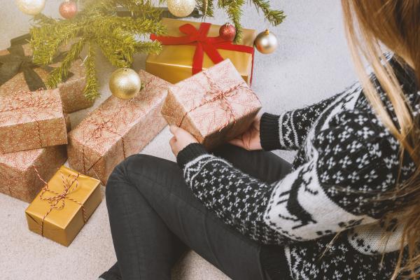 Woman in Sweatshirt and Jeans Holding a Gift Box