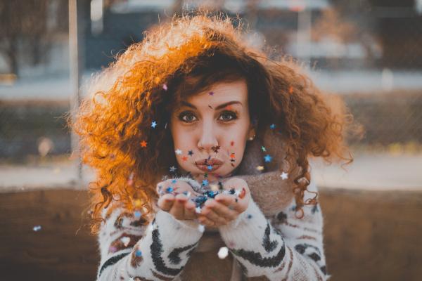 Woman in White and Black Sweater Blowing Confetti