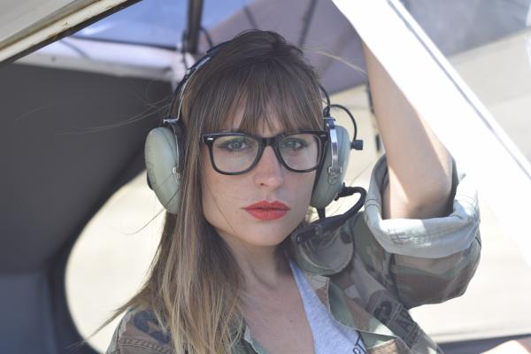 Woman in White Frame Eyeglasses Wearing Camouflage Shirt