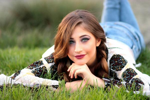 Woman Lying on Green Grass Field during Daytime