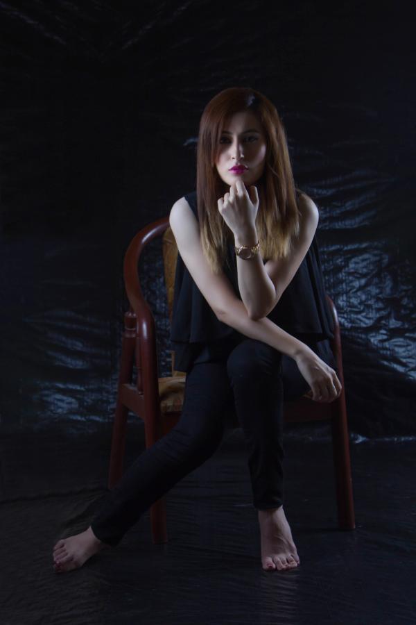 Woman Sitting on Brown Chair With Black Background