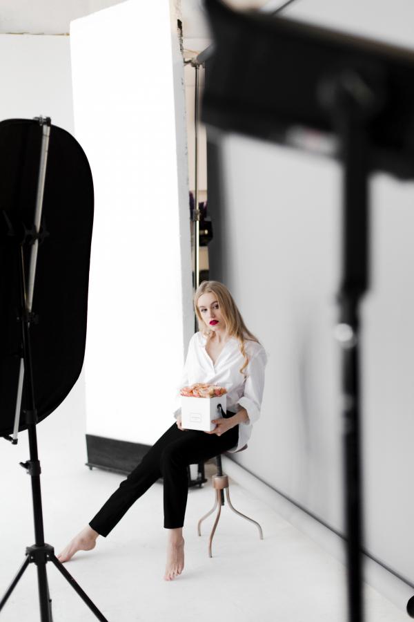Woman Sitting on Stool While Holding Box