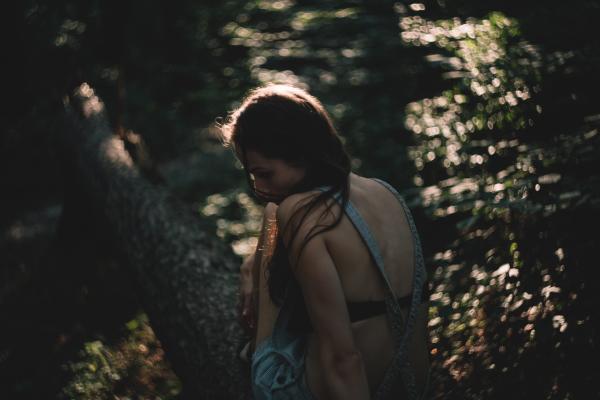 Woman Sitting on Tree Trunk during Daytime