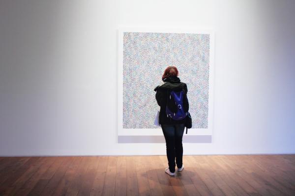 Woman Standing Infront of a Wall Mount Painting
