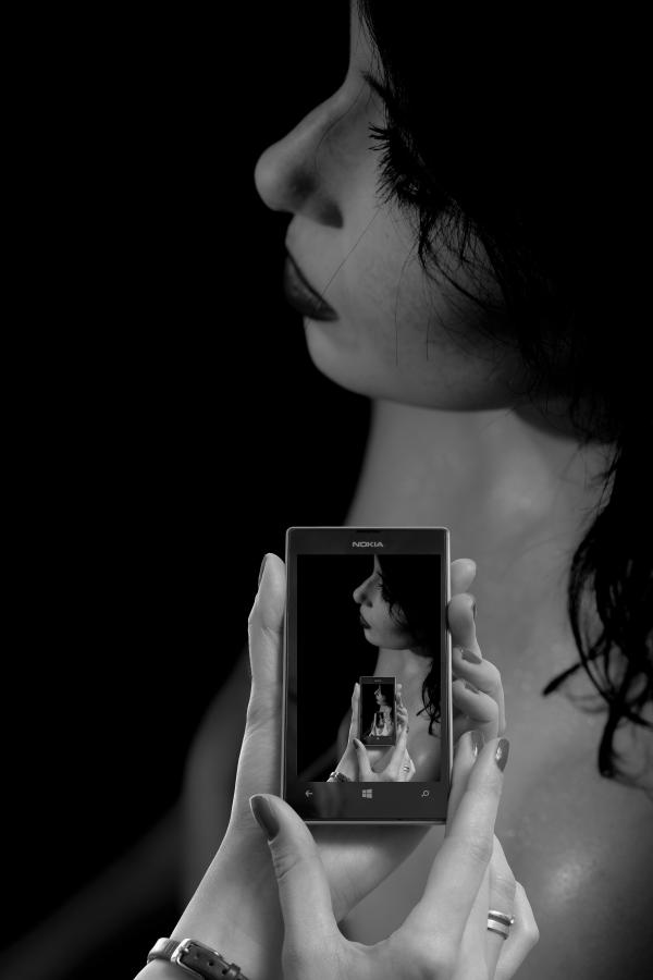 Woman Using Smart Phone Against Black Background