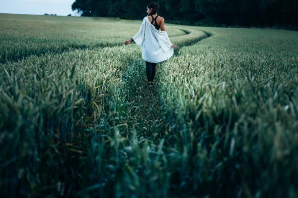 Woman Walking in the Rice Plant Field during Daytime