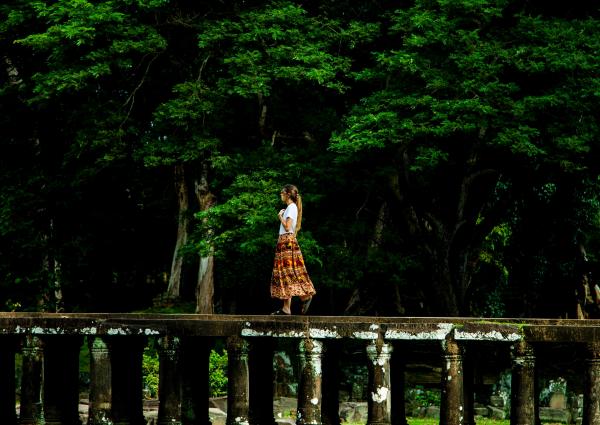 Woman Walking on Bridge Surrounded by Trees