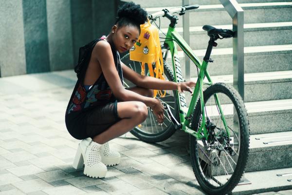 Woman Wearing Black Dress Seating Near Green Bicycle