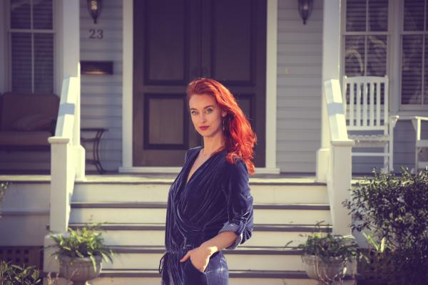 Woman Wearing Black Jumpsuit Standing Near the House