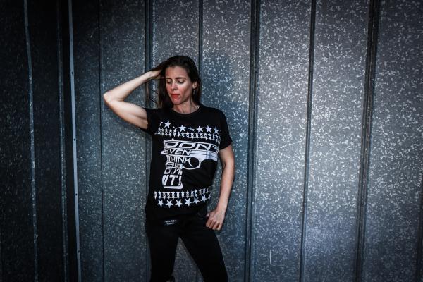Woman Wearing Black Shirt and Pants Near Gray Wall