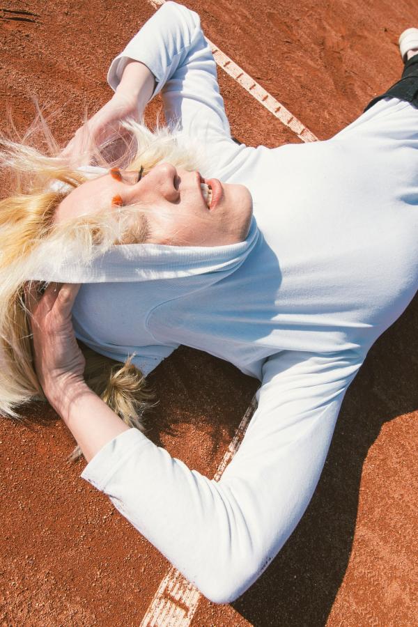 Woman Wearing Pull over Hoodie Laying on Brown Carpeted Floor