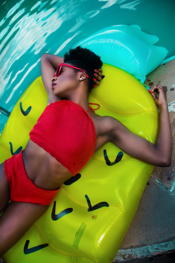 Woman Wearing Red Bikini Top With Pantie Laying on Inflatable Bed