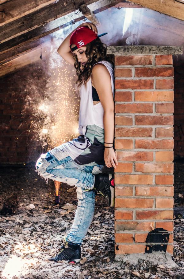 Woman Wearing White Tank Top Leaning on Brown Brick Wall