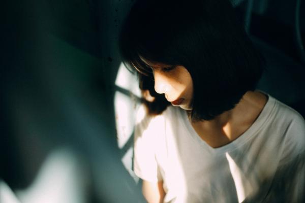 Woman Wearing White V Neck T Shirt Leaning on White Wall