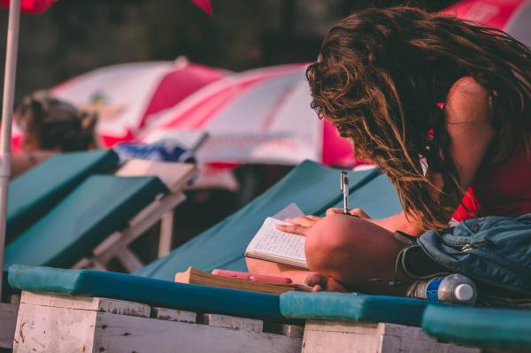 Woman With Red Top Holding Pen and Notebook