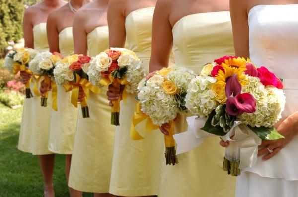 Women Wears White and Yellow Tube Strapless Dresses Holding White, Red, and Yellow Bouquet