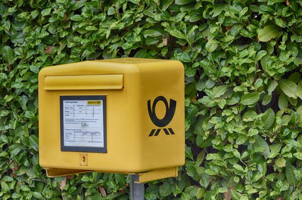 Yellow Postbox on green background of leaves